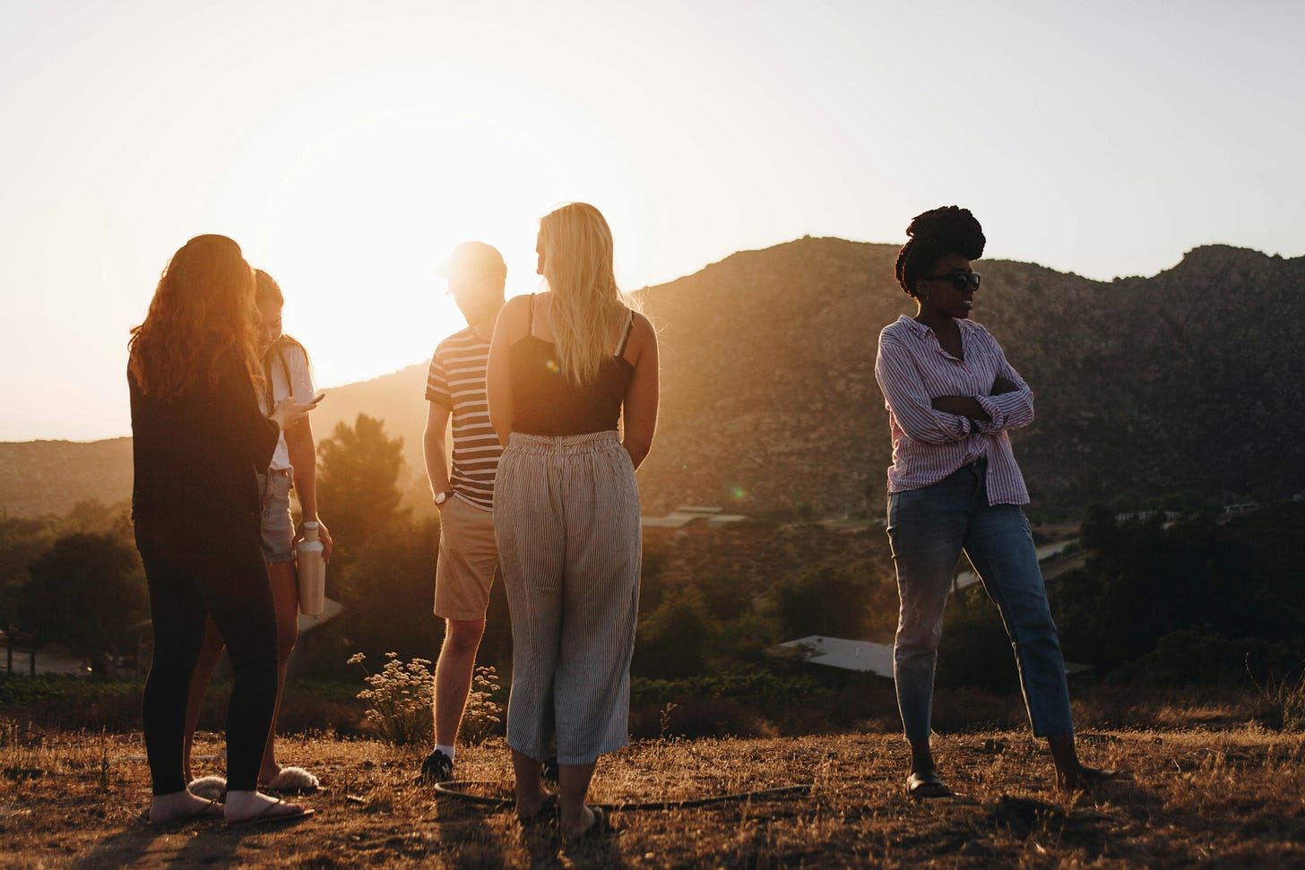 Group of people outdoors in the sun. Photo by Luke Porter via Unsplash.