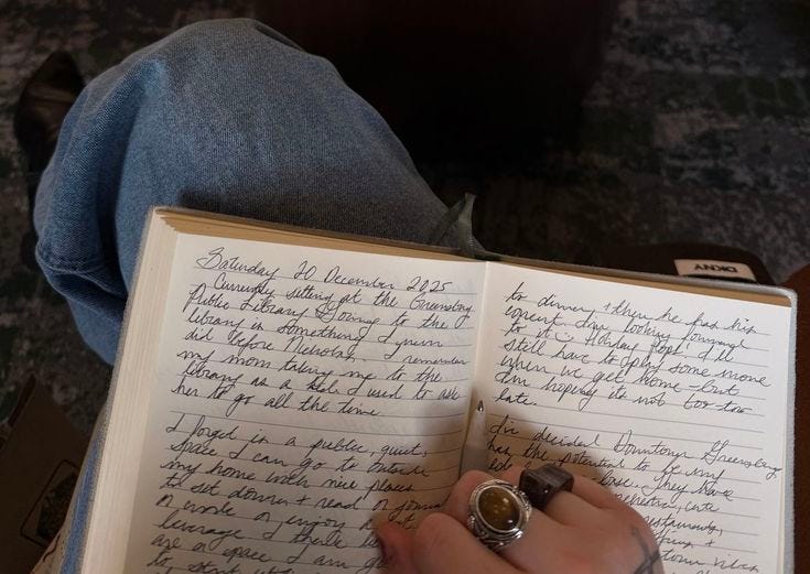 This may contain: a person is holding an open book with writing on it and there are two rings on their thumbnails