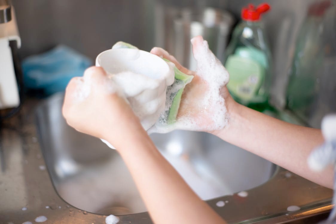 From https://www.pexels.com/photo/a-person-washing-the-cup-using-a-foam-7492926/