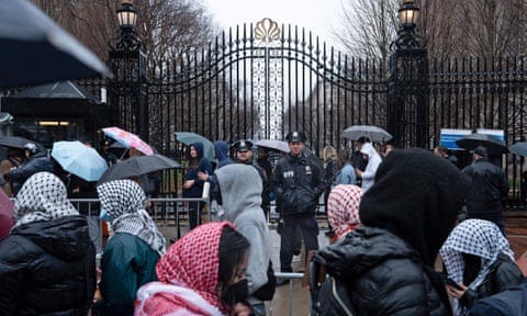 crowd wearing keffiyehs outside columbia gates at protest