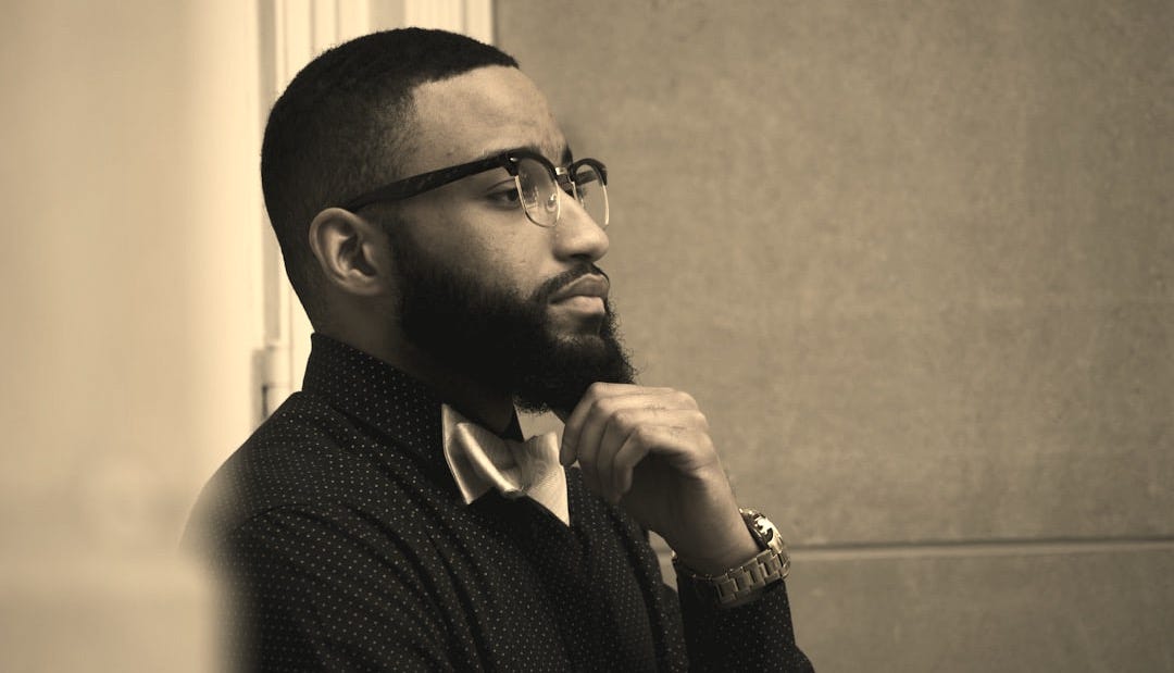 a man with a beard and glasses looking off into the distance