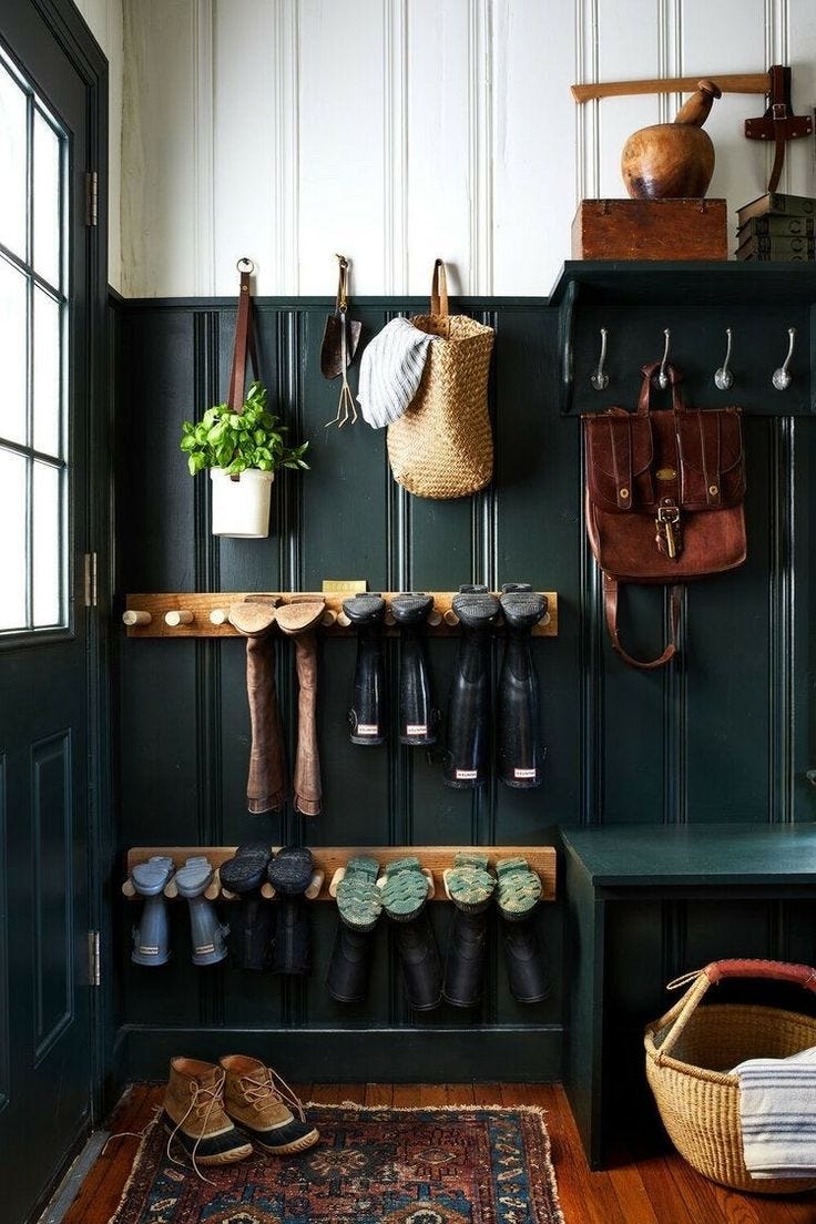 This may contain: an entryway with shoes and umbrellas hanging from the hooks on the coat rack