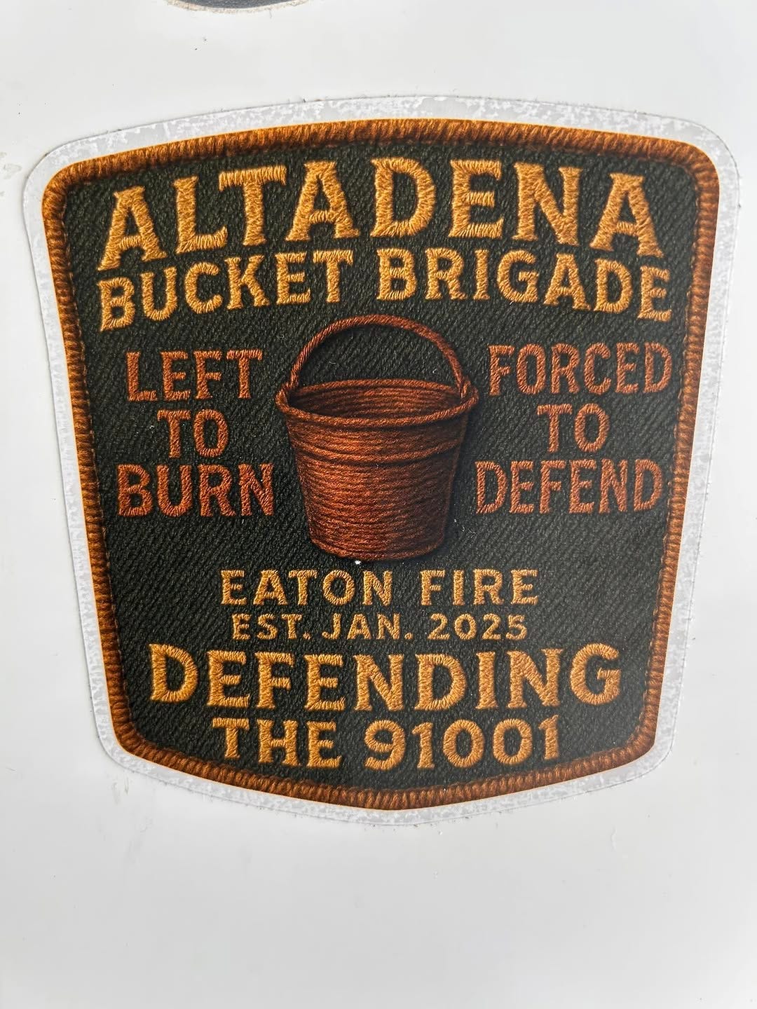 May be an image of text that says 'ALTADENA ENA A BUCKETBRIGADE BUCKET BRIGADE LEFT ウ物 有 FORCED TO TO BURN DEFEND EATON মকাঙেস FIRE EST.JAN. JAN. 2025 EST. DEFE DEFENDII ENDING THE 91001'