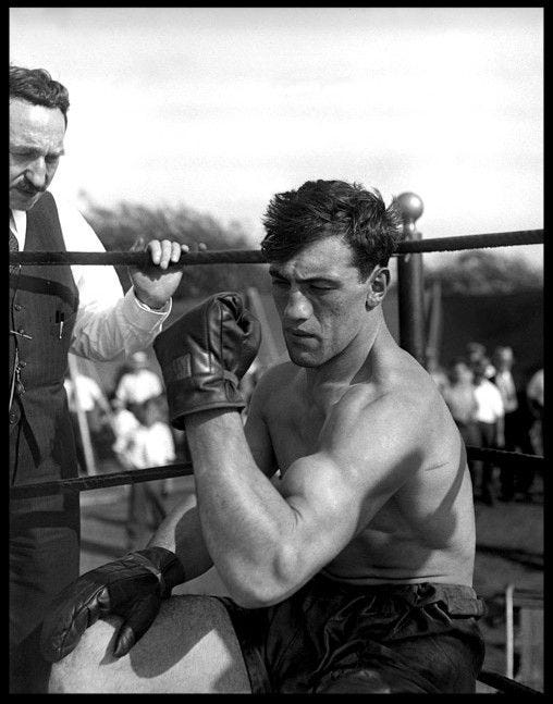 This may contain: a black and white photo of a man with boxing gloves on
