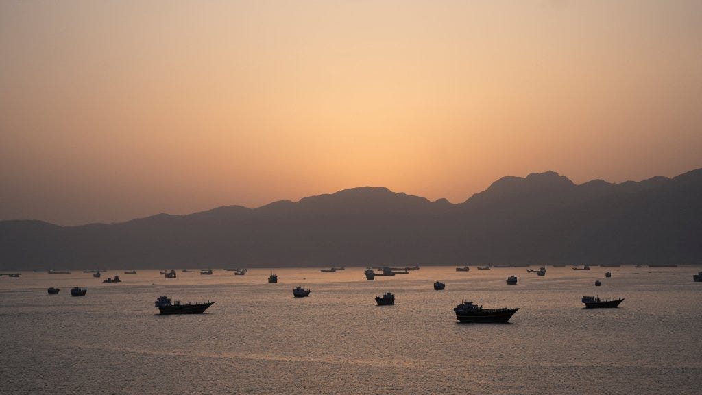 Ships and boats in the Strait of Hormuz at sunset. Ships and boats in the Strait of Hormuz at sunset.