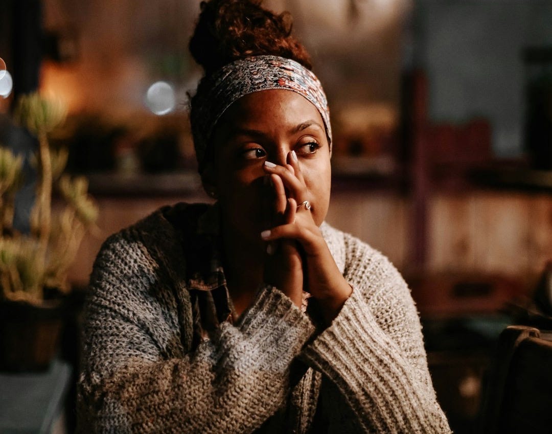 man in black and white sweater sitting on chair