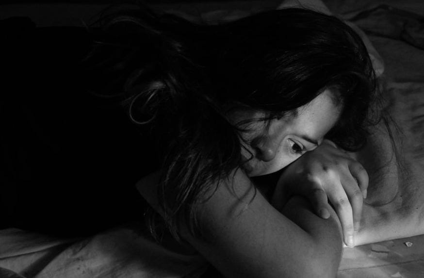 woman leaning on bed