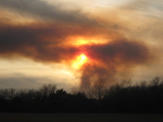 A sunset behind plumes of smoke from a wildfire. A sunset behind plumes of smoke from a wildfire.