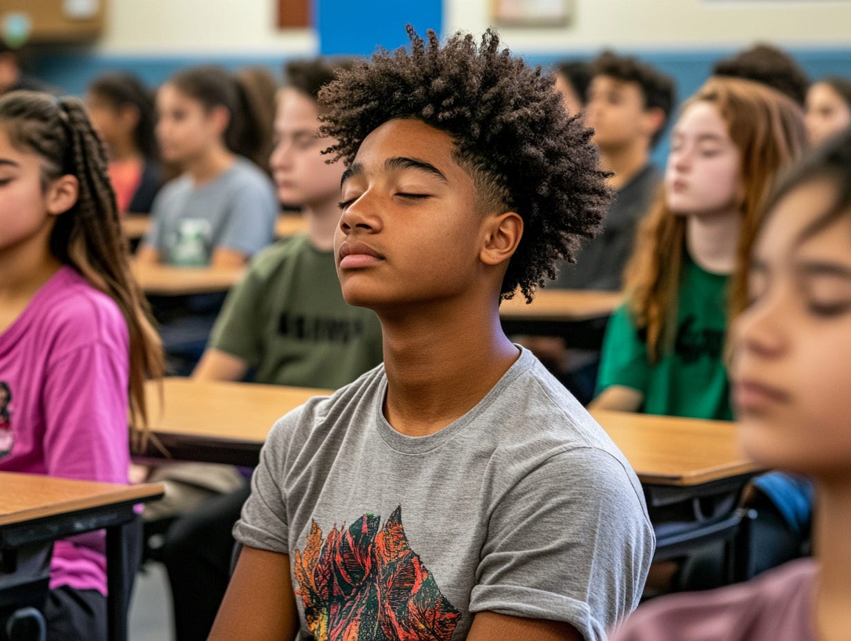 Middle school students sit at their desks with eyes closed, practicing a calm breathing or mindfulness routine. A boy in the foreground wears a gray T-shirt and looks relaxed, while classmates behind him sit quietly with similar peaceful expressions. Middle school students sit at their desks with eyes closed, practicing a calm breathing or mindfulness routine. A boy in the foreground wears a gray T-shirt and looks relaxed, while classmates behind him sit quietly with similar peaceful expressions.