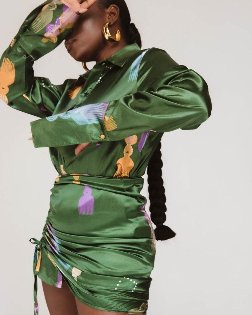 A black woman in a green blouse and mini skirt