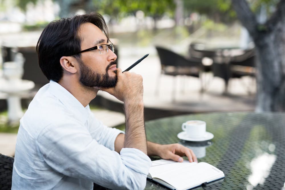 Man thinking while writing