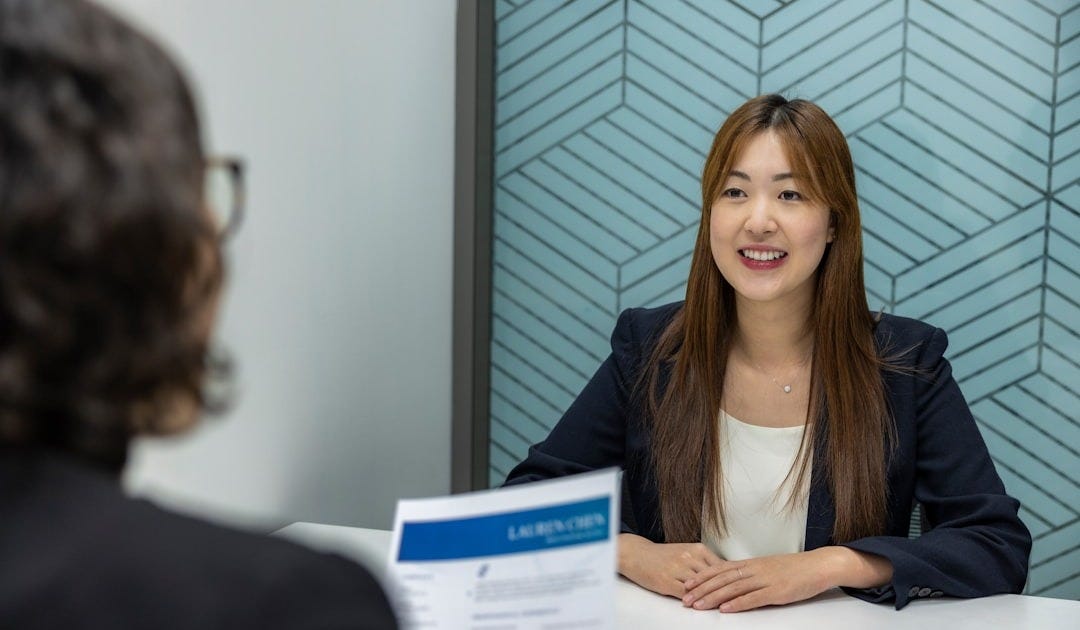 a woman sitting at a table with a piece of paper in front of her a woman sitting at a table with a piece of paper in front of her