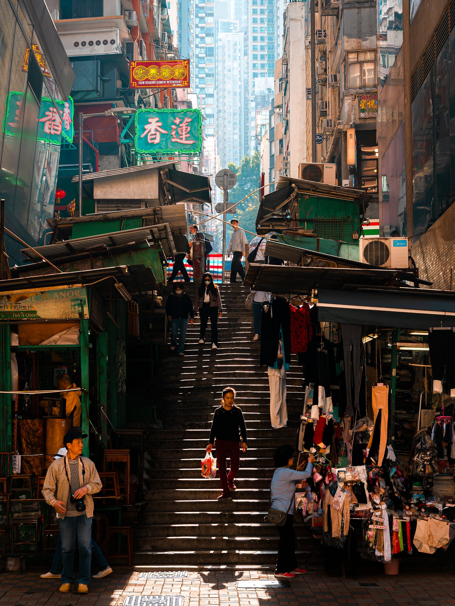 Aberdeen Street steps in Central, Hong Kong, with sunlight falling across stone steps and market stalls Aberdeen Street steps in Central, Hong Kong, with sunlight falling across stone steps and market stalls