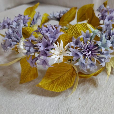 Artistic flowers made of paper, blue cornflowers, lilac peony and purple lavender, all coloured using red cabbage.