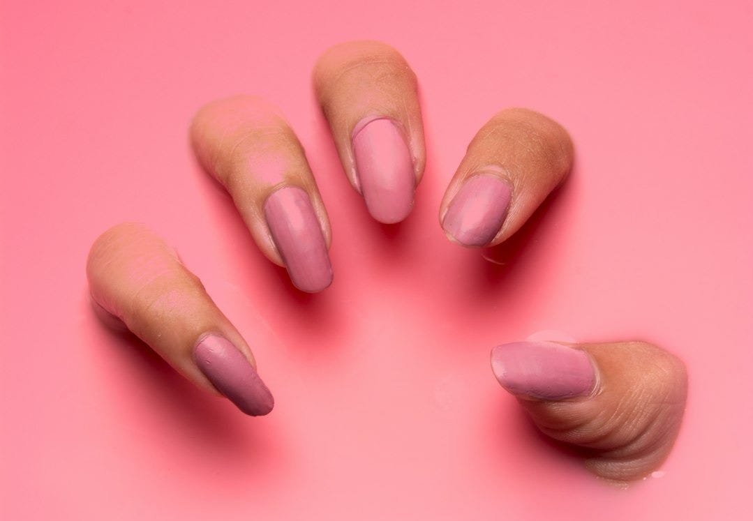 persons hand on pink surface persons hand on pink surface