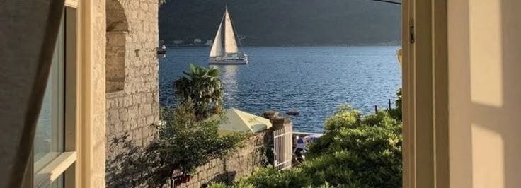 This may contain: a sailboat is sailing on the water from an alley way