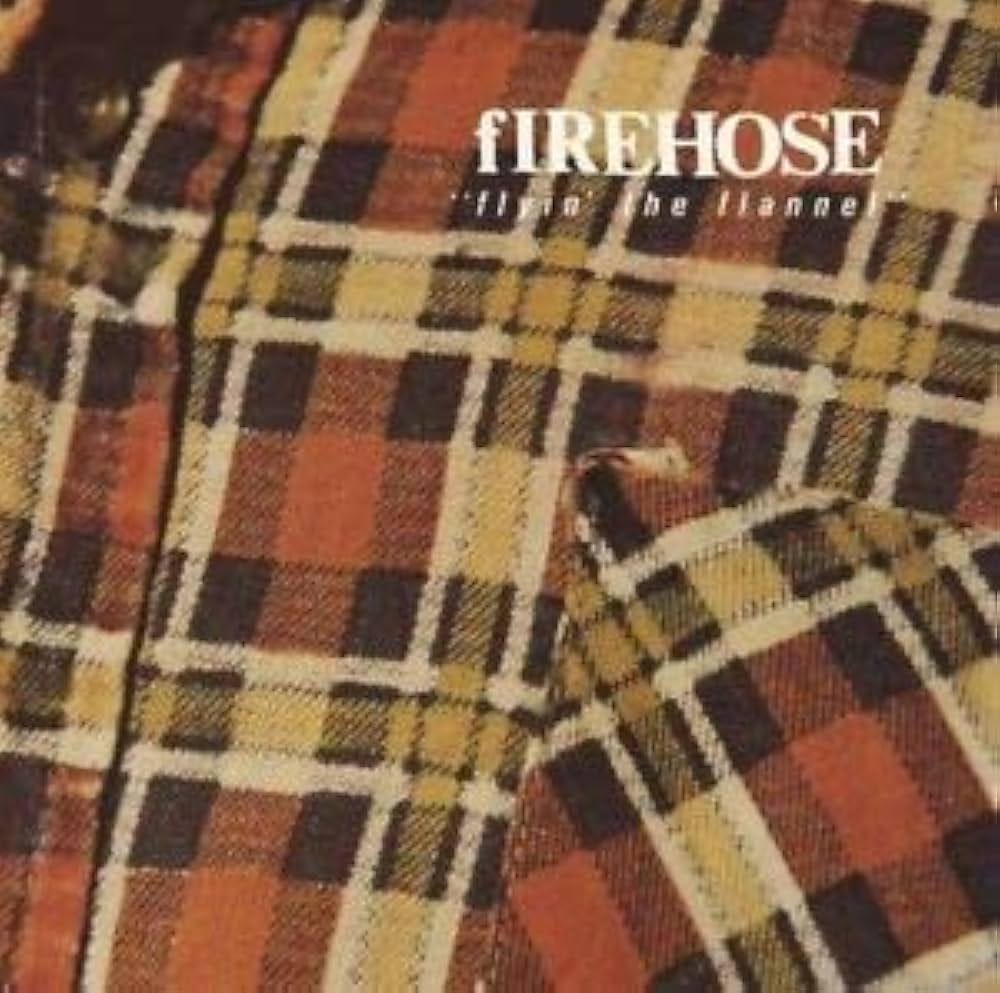 cover of flyin the flannel by firehose; cover image is of a flannel shirt, very close up on area around pocket