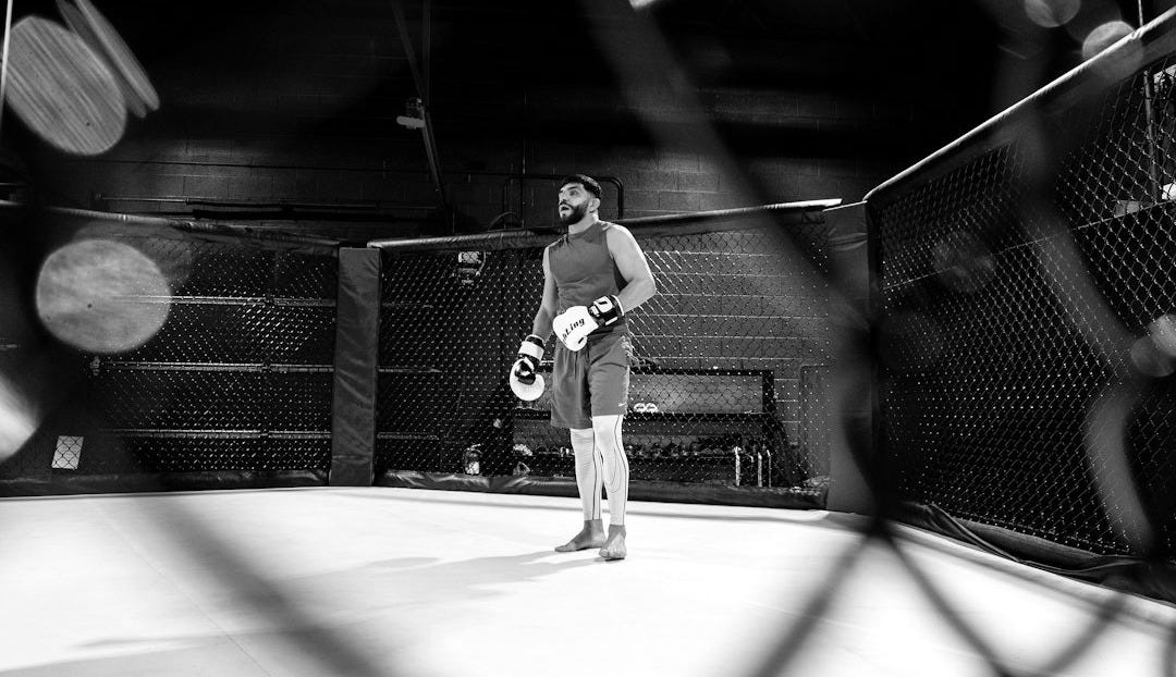 A man standing in the middle of a boxing ring A man standing in the middle of a boxing ring