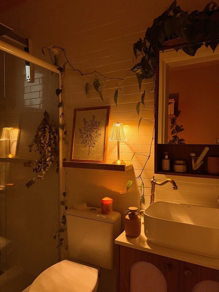 This may contain: a bathroom with a toilet, sink and shower