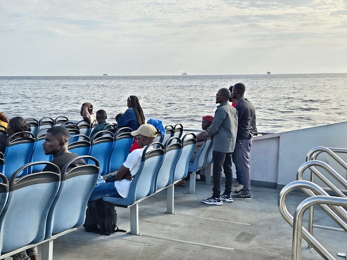 Open seating on upper deck of ferry, ocean on horizon.