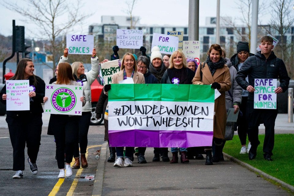 Protestors holding signs supporting Sandie Peggie at an employment tribunal.
