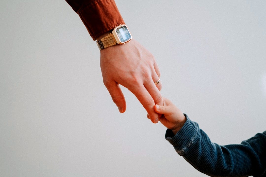 a person holding the hand of a child a person holding the hand of a child
