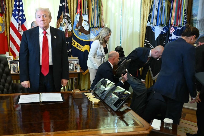 US President Donald Trump looks on after a man fainted