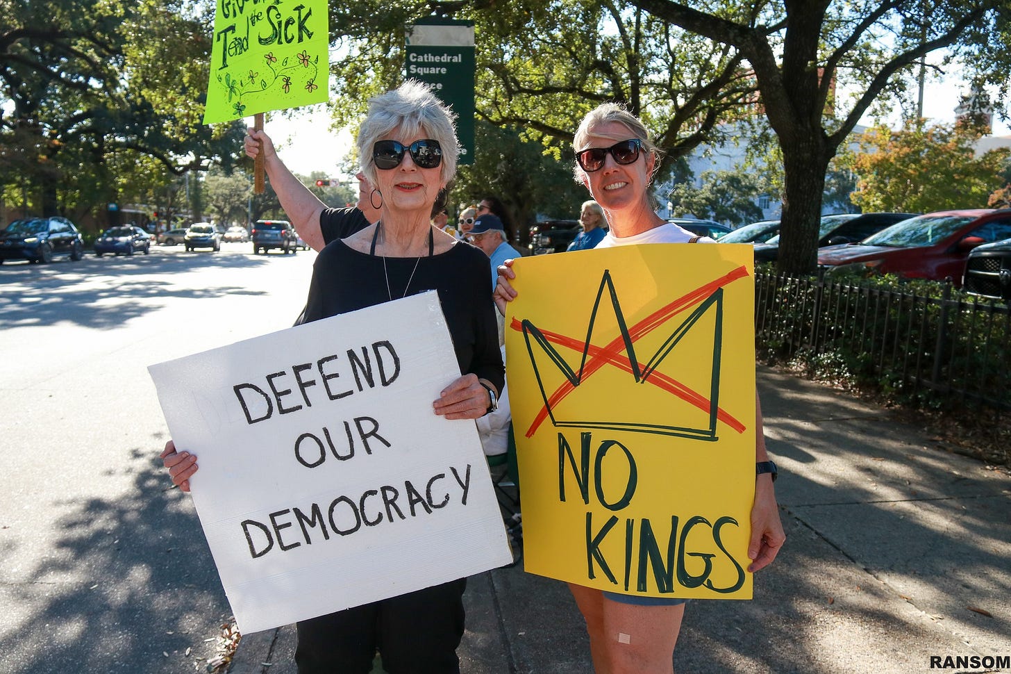 May be an image of text that says 'Tal"Sick Temd Sick Cathedral Square น DEFEND OUR DEMOCRACY DEMOCRACY NO KINGS RANSOM'