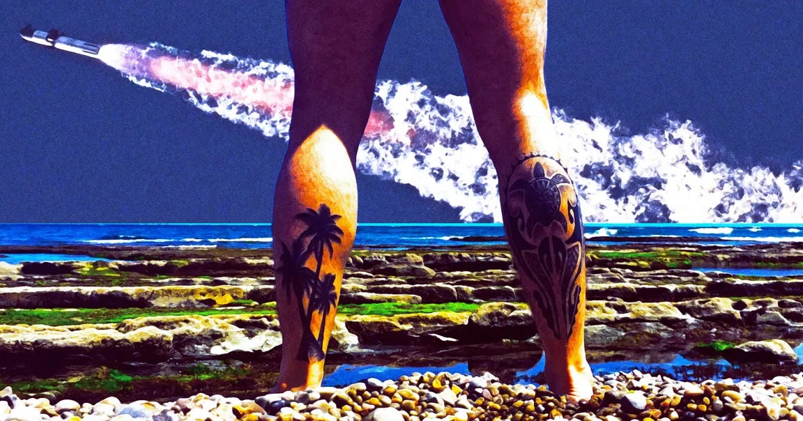 Tattooed legs of a nude beachgoer with a SpaceX rocket launching in the background.