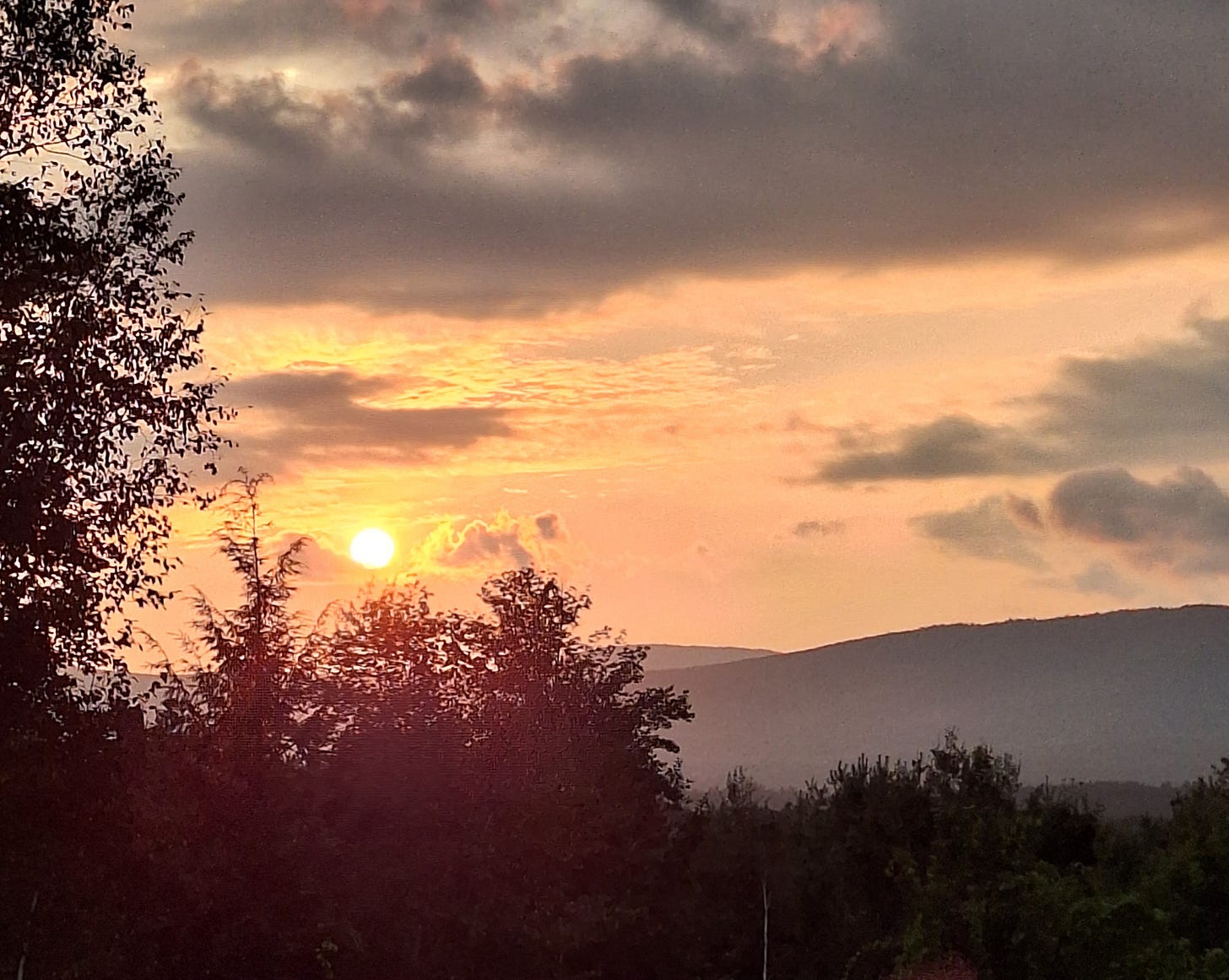 Photo of the sun setting over mountains taken from my front yard. 