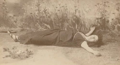 Actress lying dead on a stage.
