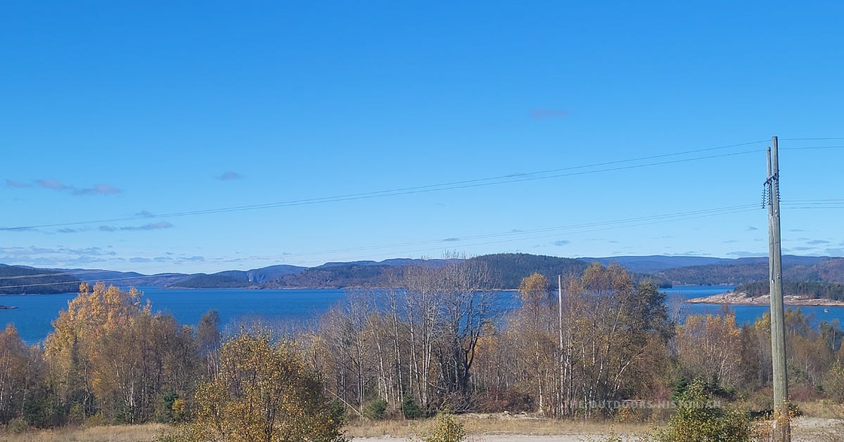 A horizontal landscape view from a lookout in Marathon, Ontario. The rugged, undulating topography of the ancient Canadian Shield is visible under a sunny fall sky, overlooking the landscape that defines the North Shore.