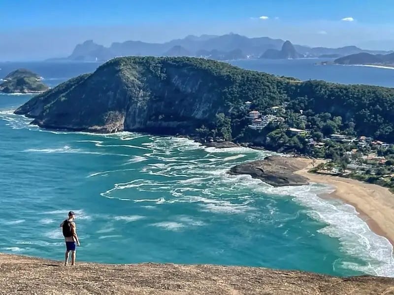 Best hikes in Rio de Janeiro - Costao de Itacoatiara Ian looks out from the summit of Costao de Itacoatiara towards Rio