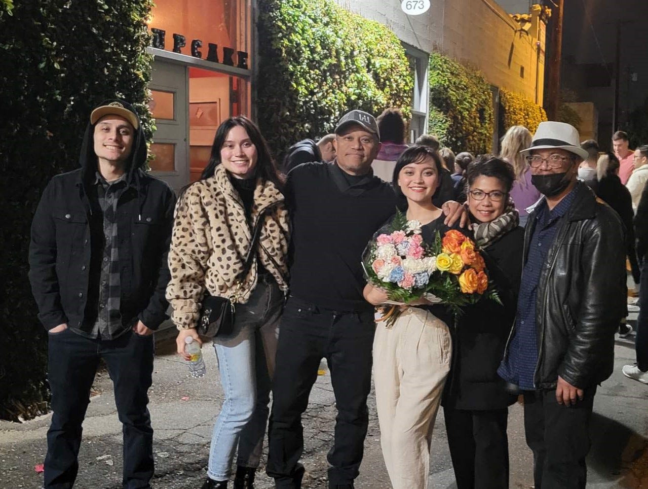 Tugangui family (left to right: Nick, Liza, Perry, Amanda, Evelyn, Jerry) smiling in front of the Cupcake Theatre.