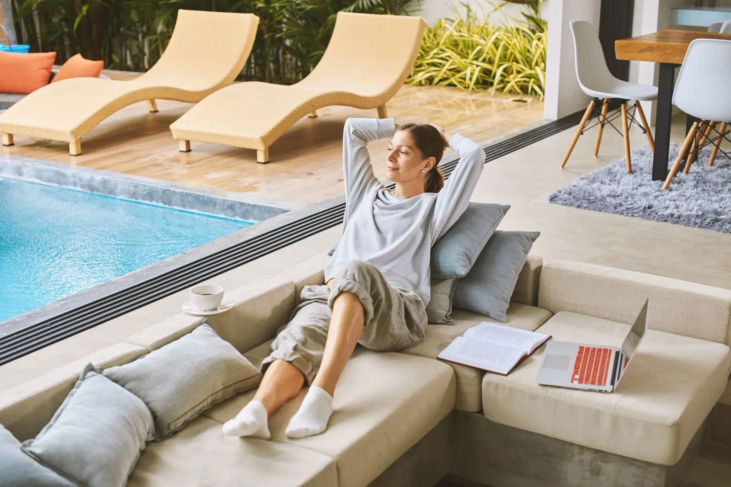 A young woman taking a break from studying by the pool