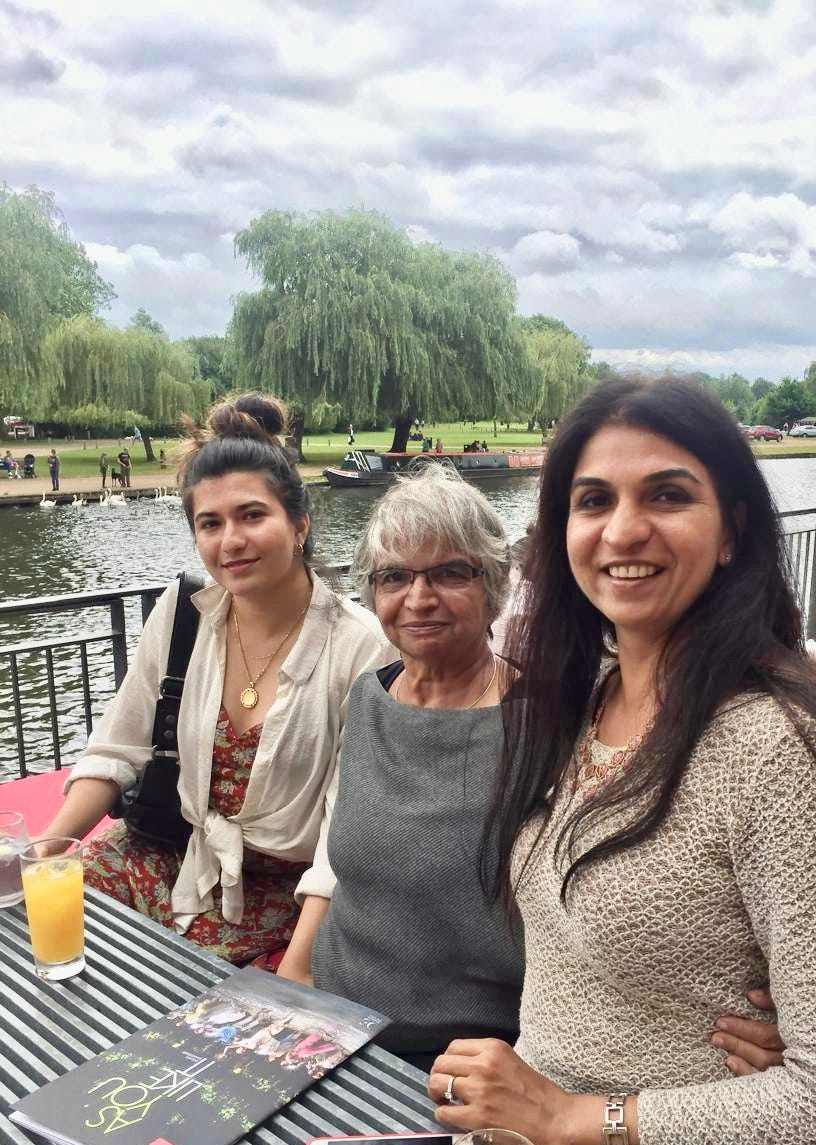 Three women smiling together outdoors, representing three generations behind Evara