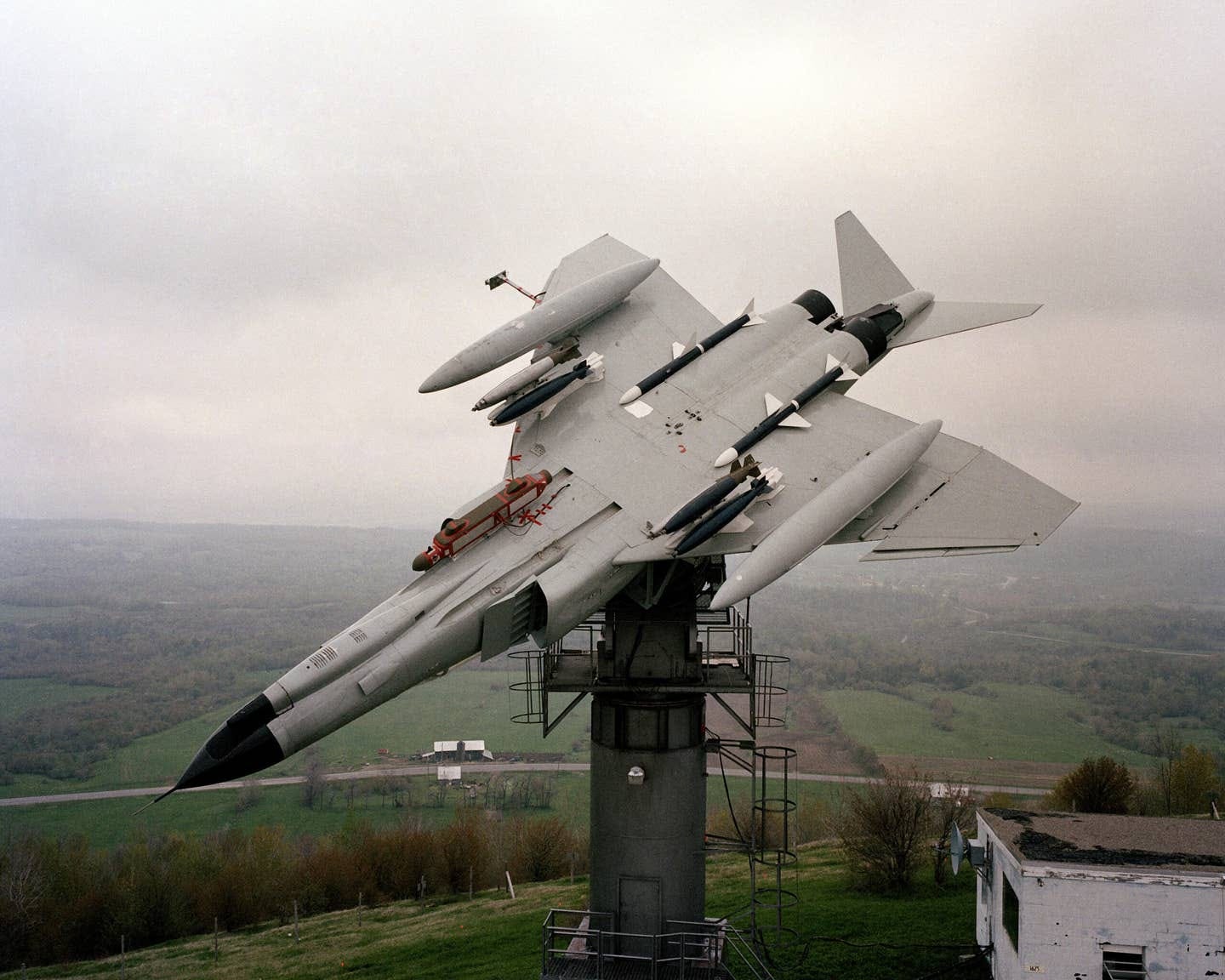 An F-4 Phantom II aircraft shows one angle of its weapon configuration while atop a pedestal at the Rome Air Development Center's Newport test site, May 1984. The aircraft's antennas are being evaluated during the test. <em>National Archives</em>