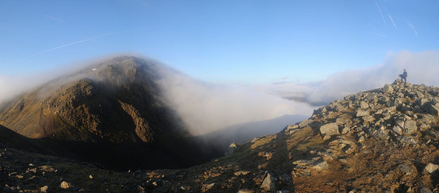 crags shrouded in mist, photographer on right