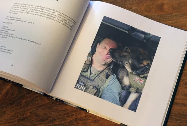 A photo in a book of a K-9 dog licking Mr. Simpson’s face.