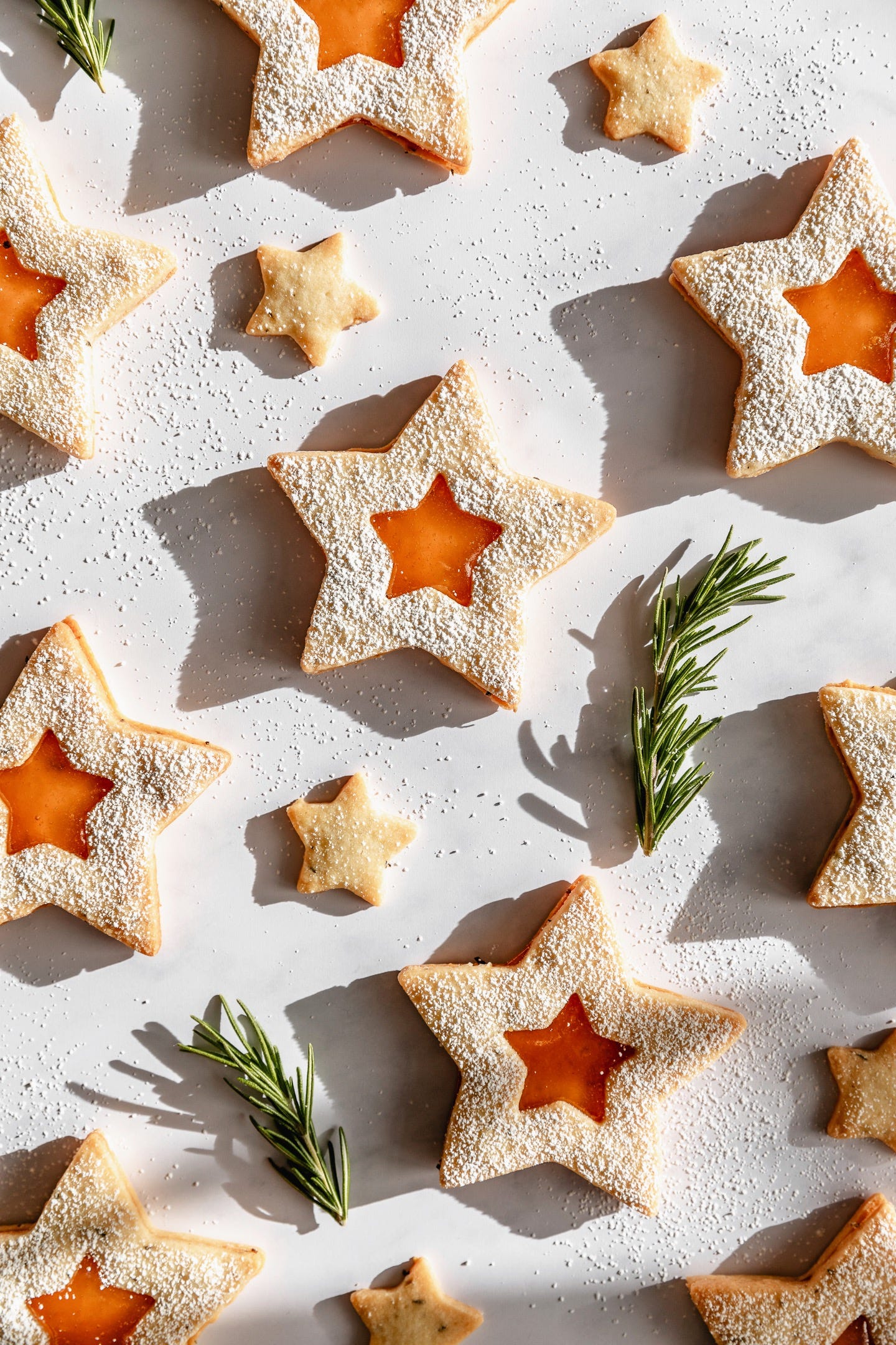 Vegan rosemary apricot linzer stars on white background Vegan rosemary apricot linzer stars on white background