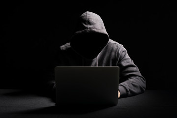 Hacker working on laptop in the dark Hacker working on laptop in the dark