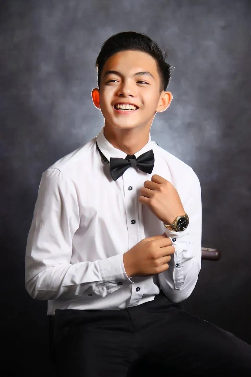 man in white dress shirt with black bowtie smiling