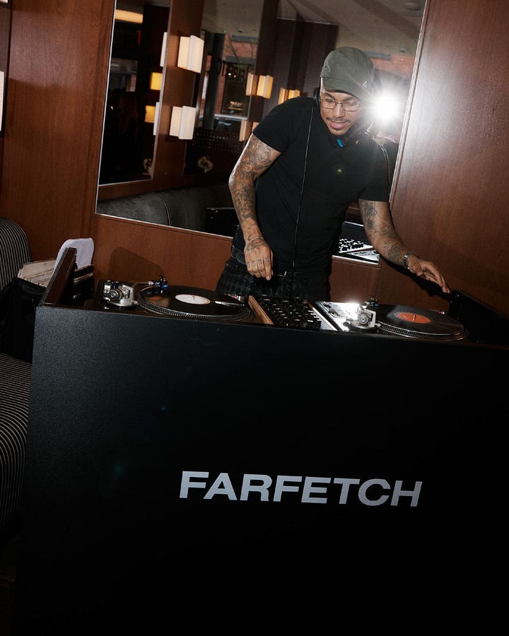 Guests among floral displays and a DJ at FARFETCH’s New York Fashion Week gathering.