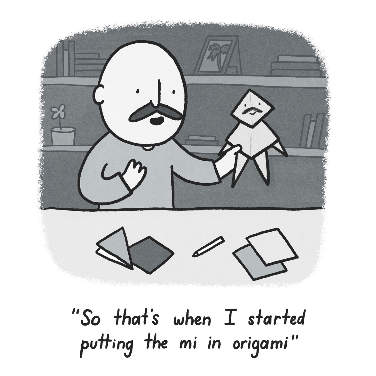 Black and white cartoon of a bald man with a moustache sitting at a desk with folded sheets of paper on it. He is holding a small figure made of origami with a moustache and face drawn on. The cartoon is captioned: "So that's when I started putting the mi in origami"