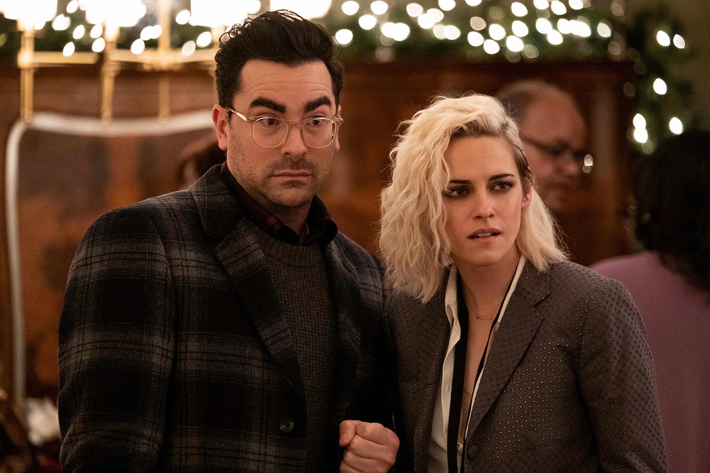Kristen Stewart and Dan Levy staring critically.
