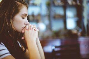 woman sitting with eyes closed in bar grieving woman sitting with eyes closed in bar grieving