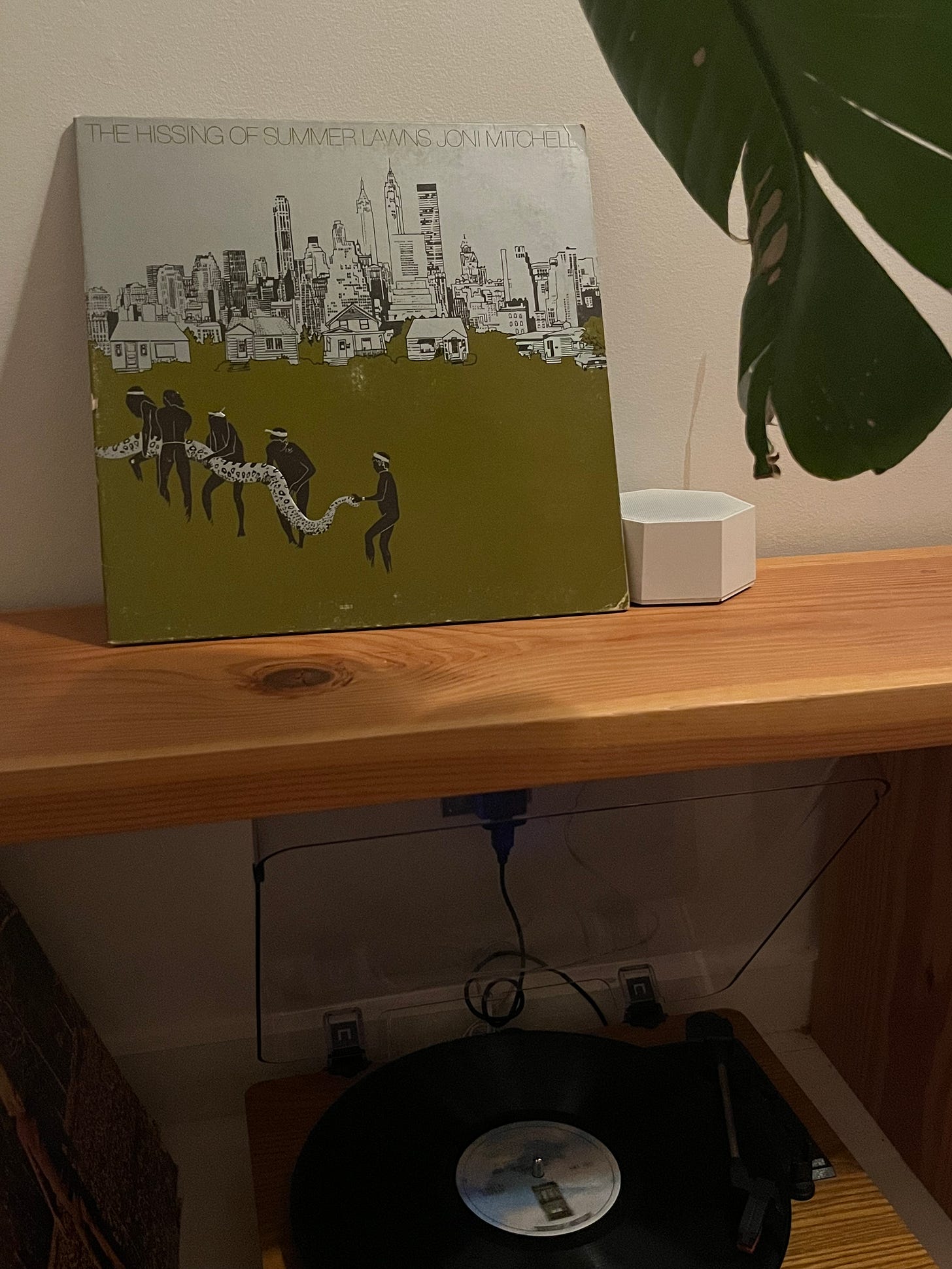 The Hissing of Summer Lawns Album perched on a bench above a record player
