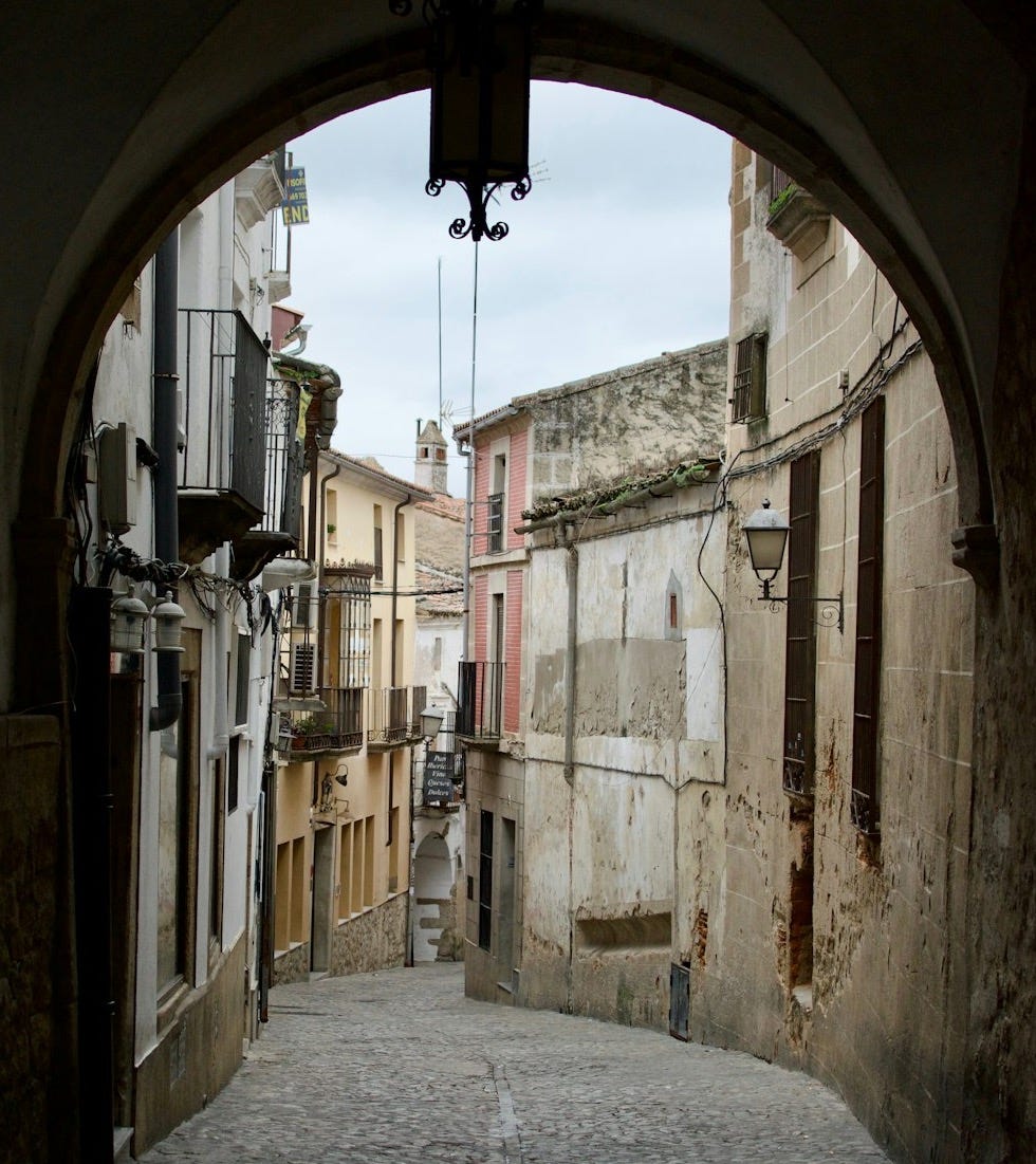 A narrow alley way with a clock on the wall