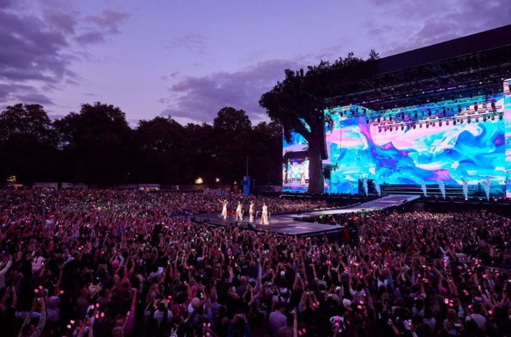 A festival crowd watching performers on a stage A festival crowd watching performers on a stage