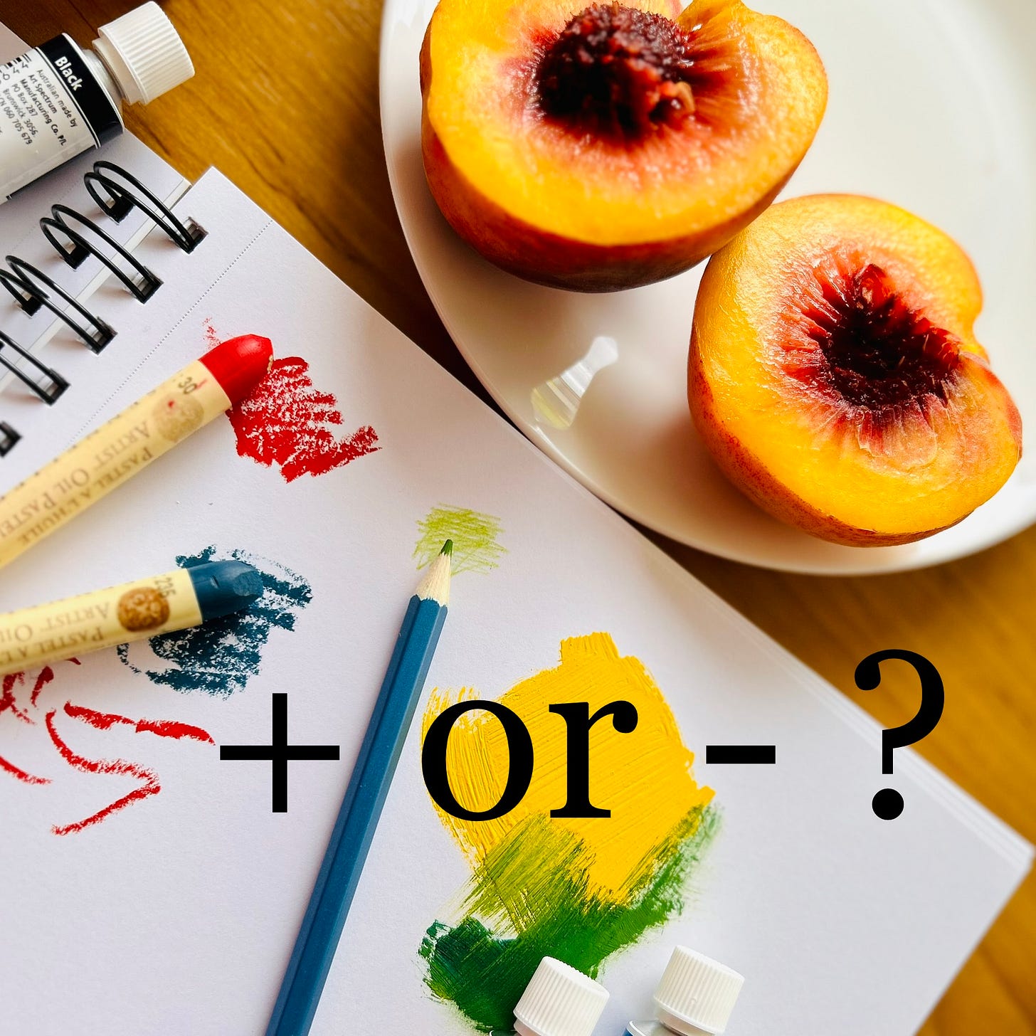 A luscious peach, halved on a plate with a sketchbook and bright coloured doodles in oil pastel, pencil and goache .
